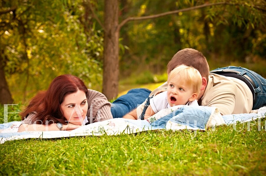 Parents resting on grass with their child outside