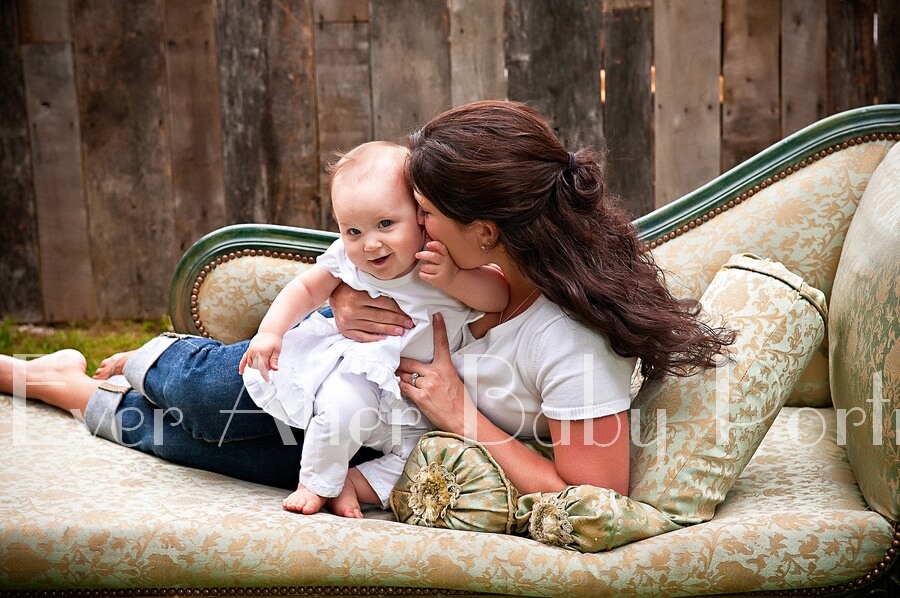 Mommy and baby on sofa for outdoor portrait.