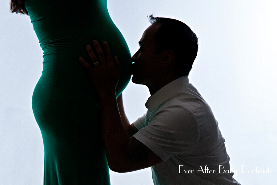 husband kisses unborn child